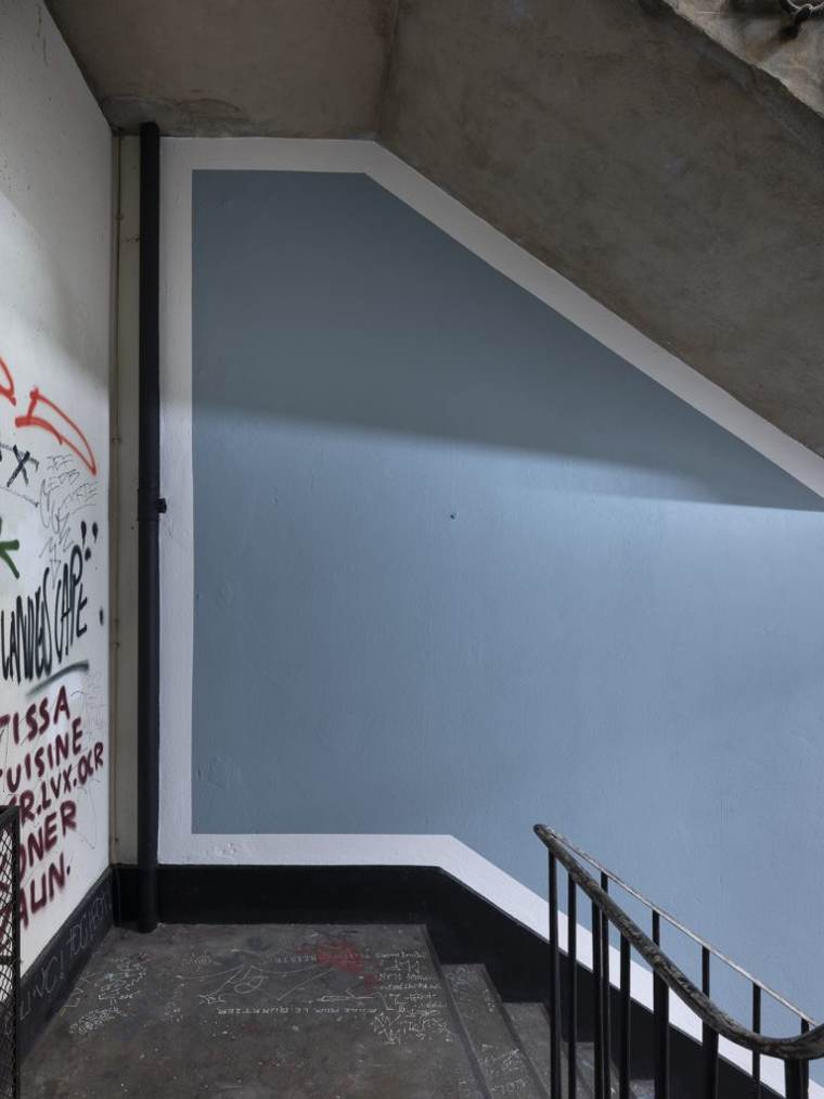Pale blue wall painting in a concrete stairwell