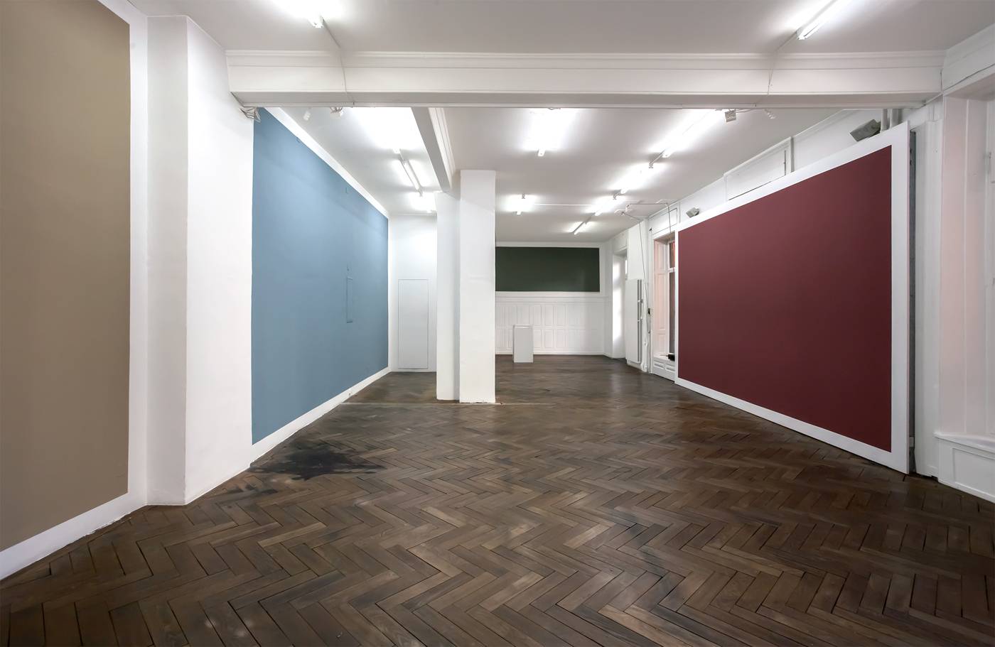 Gallery interior with large blue and deep red wall paintings