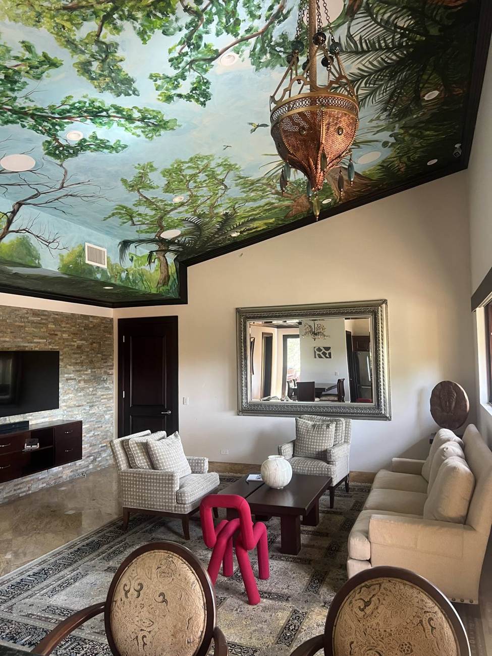 Living area beneath the painted ceiling, with chandelier